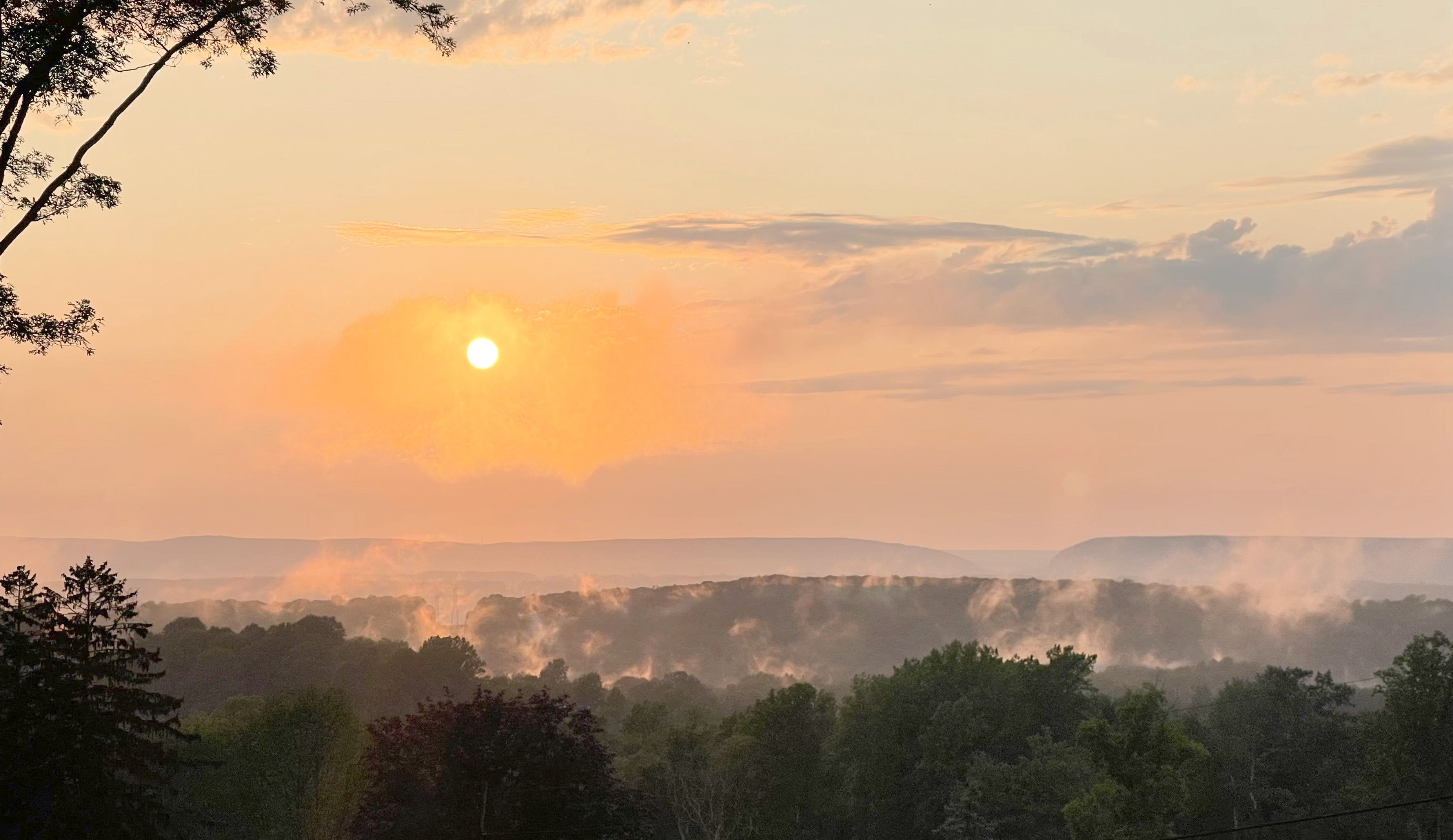 Sunset over wooded ridges, supplied in the property folder. Exact viewpoint has not been verified.